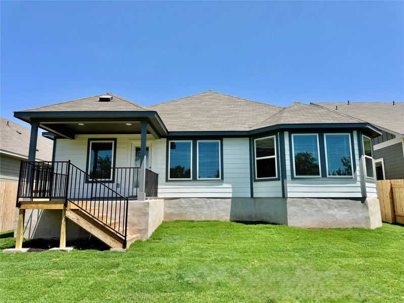 Rear view of property with roof with shingles and a porch Rear view of property with roof with shingles and a porch