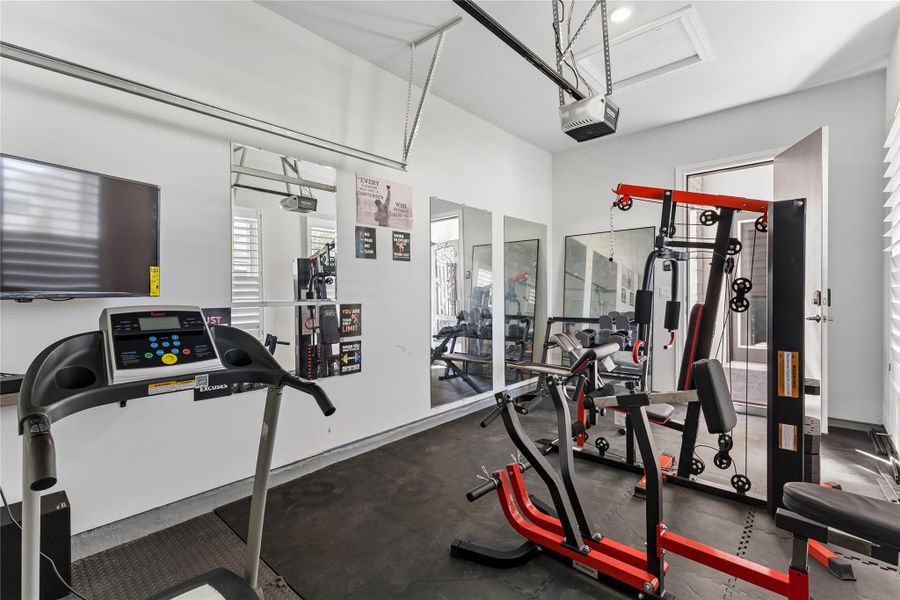 A dedicated home gym space, featuring ample workout equipment and bright illumination.