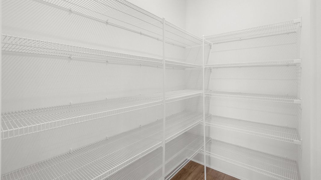 Spacious walk-in pantry with built-in shelving for organized storage. Spacious walk-in pantry with built-in shelving for organized storage.