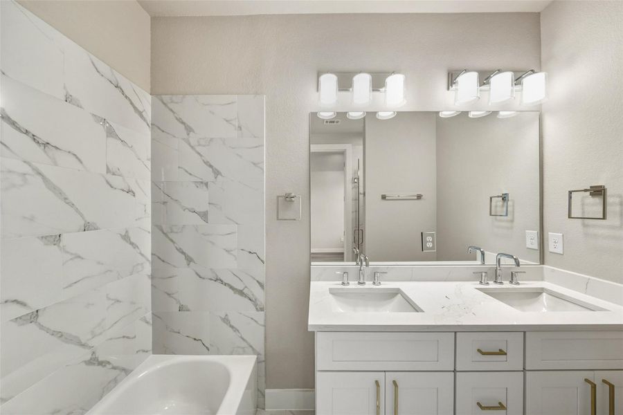 Experience luxury in this master bathroom, featuring elegant marble tiles, a sleek double vanity, and modern lighting for a spa-like retreat. Experience luxury in this master bathroom, featuring elegant marble tiles, a sleek double vanity, and modern lighting for a spa-like retreat.