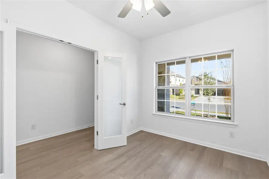 Empty room with light wood finished floors, ceiling fan, and lofted ceiling