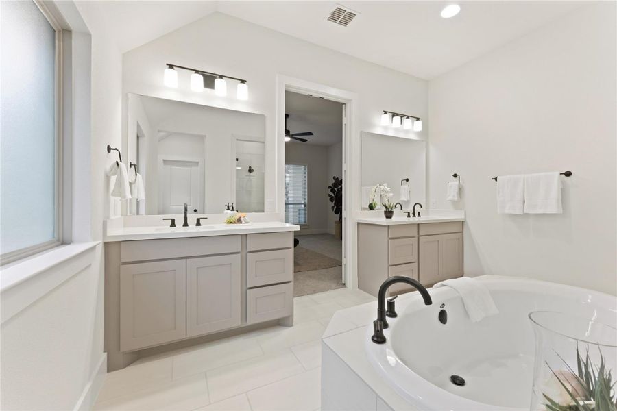 Spacious bathroom featuring a built-in soaking tub with matte black fixtures