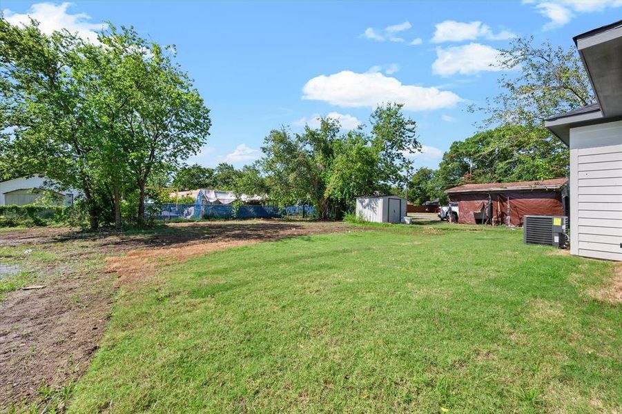 View of yard featuring a storage shed and cooling unit