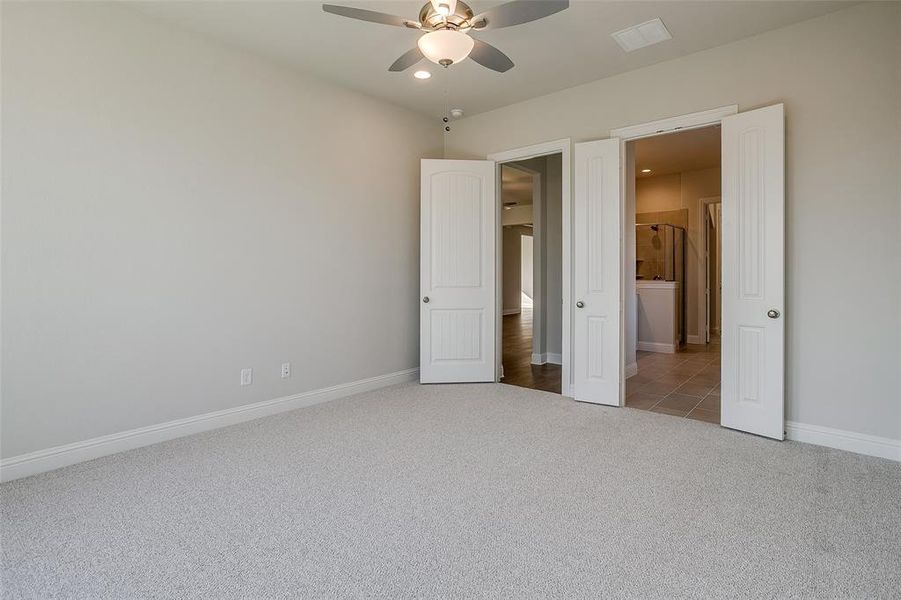 Unfurnished bedroom featuring ceiling fan and carpet