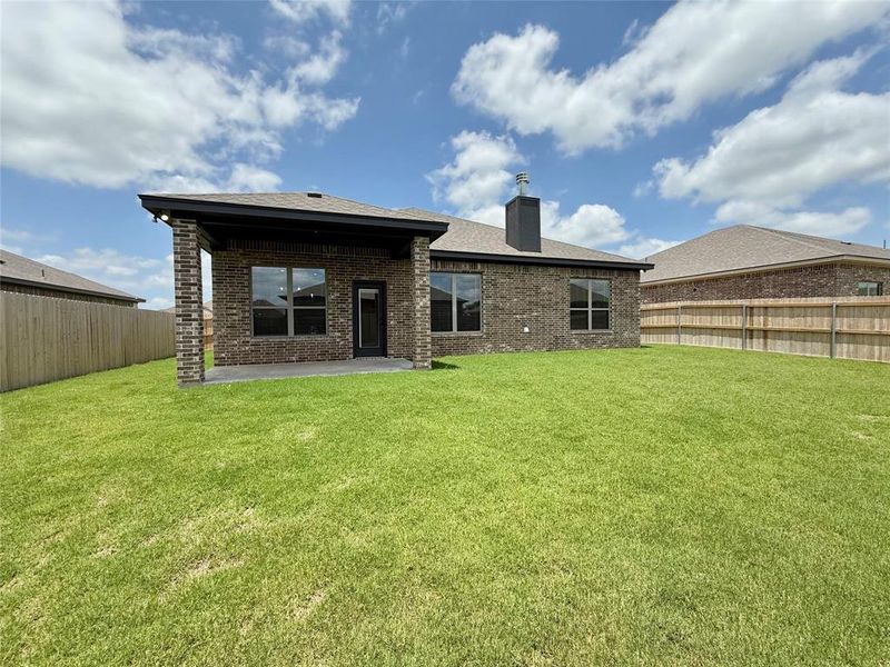 Rear view of property with brick siding, a patio, a fenced backyard, a chimney, and roof with shingles