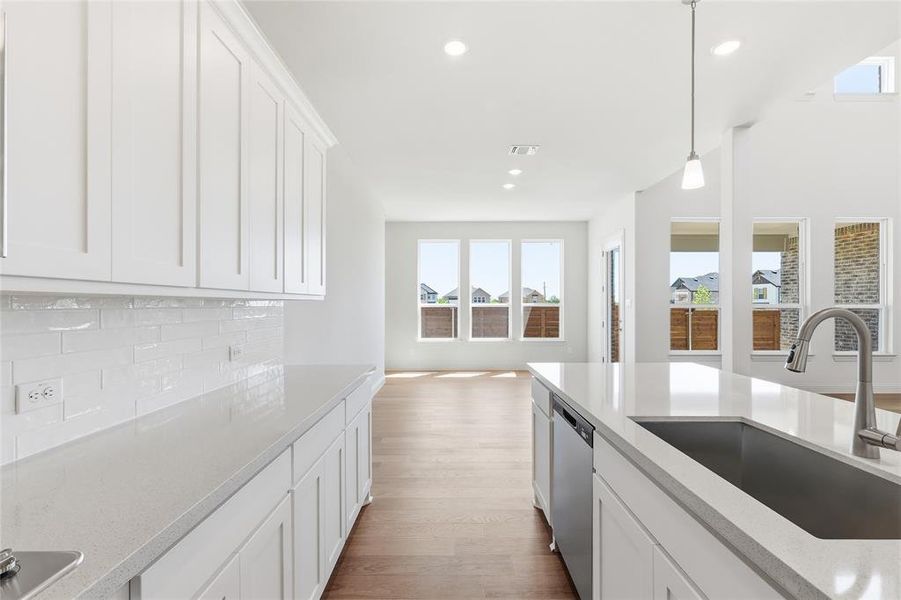 Kitchen featuring white cabinetry, light stone countertops, and plenty of natural light