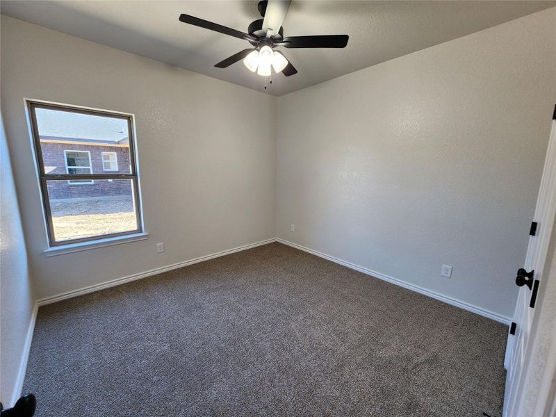 Spare room with dark colored carpet and a ceiling fan