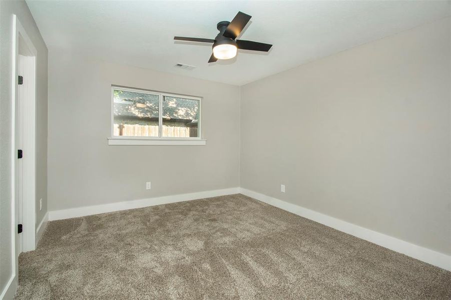 Unfurnished room with ceiling fan and carpet