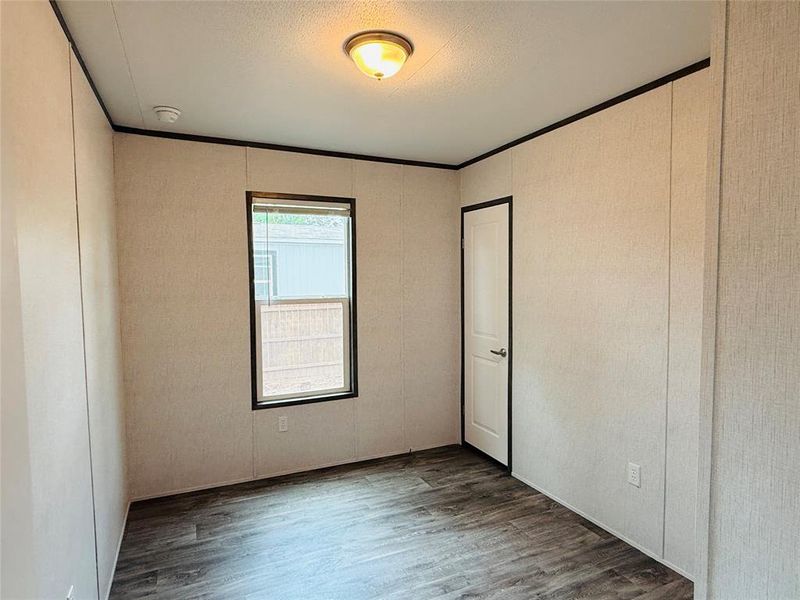 Unfurnished bedroom featuring wood finished floors and a textured ceiling