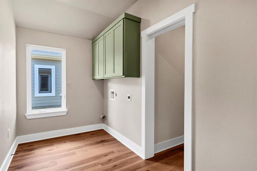Laundry room with light wood-style floors, hookup for a washing machine, cabinet space, and electric dryer hookup Laundry room with light wood-style floors, hookup for a washing machine, cabinet space, and electric dryer hookup