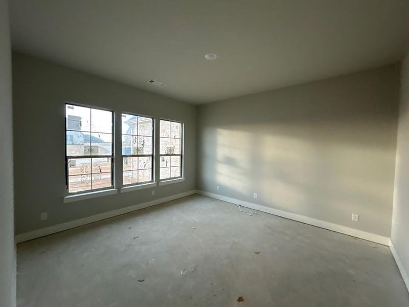Spare room featuring baseboards and unfinished concrete floors