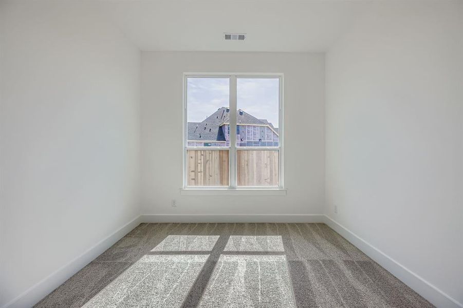 Empty room featuring light colored carpet
