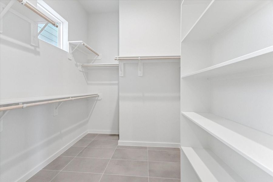 Entrance to the primary bedroom’s ensuite closet, located within the primary bathroom, offers organized, convenient access and seamless flow from the bathing and dressing areas.