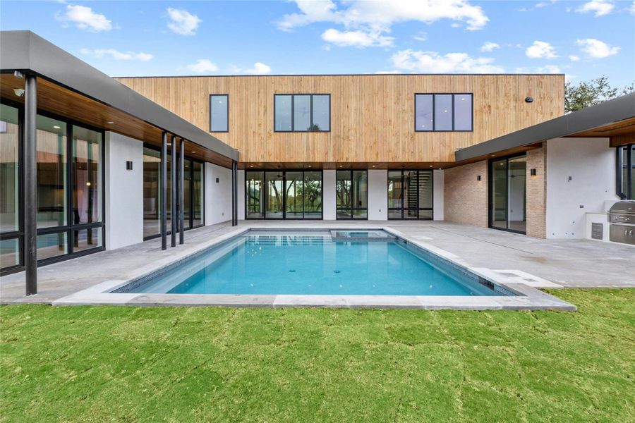 Home wraps around pool to make it a focal point: from left to right casual dining, main kitchen, great room, foyer, master bed room and outdoor kitchen. Beauty, privacy, luxury, fun.