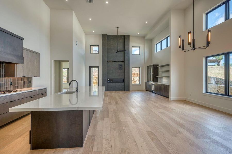 Towering ceilings and light wood floors flow seamlessly from the kitchen to the living area. Towering ceilings and light wood floors flow seamlessly from the kitchen to the living area.