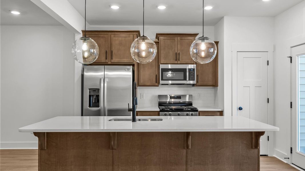 First-class kitchen with a spacious 9-foot island perfect for entertaining beneath designer pendant lighting