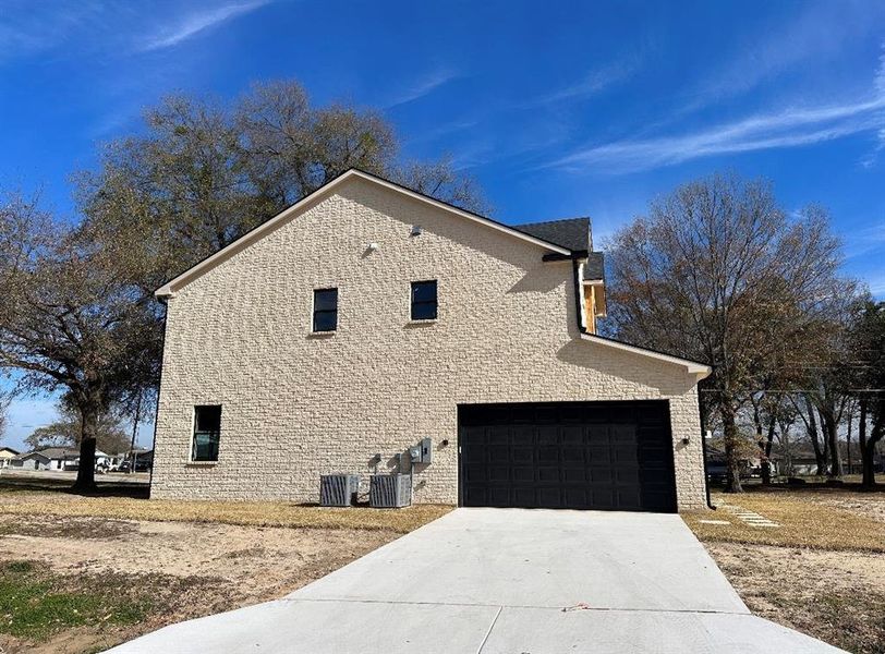 View of side of home featuring a garage and cooling unit