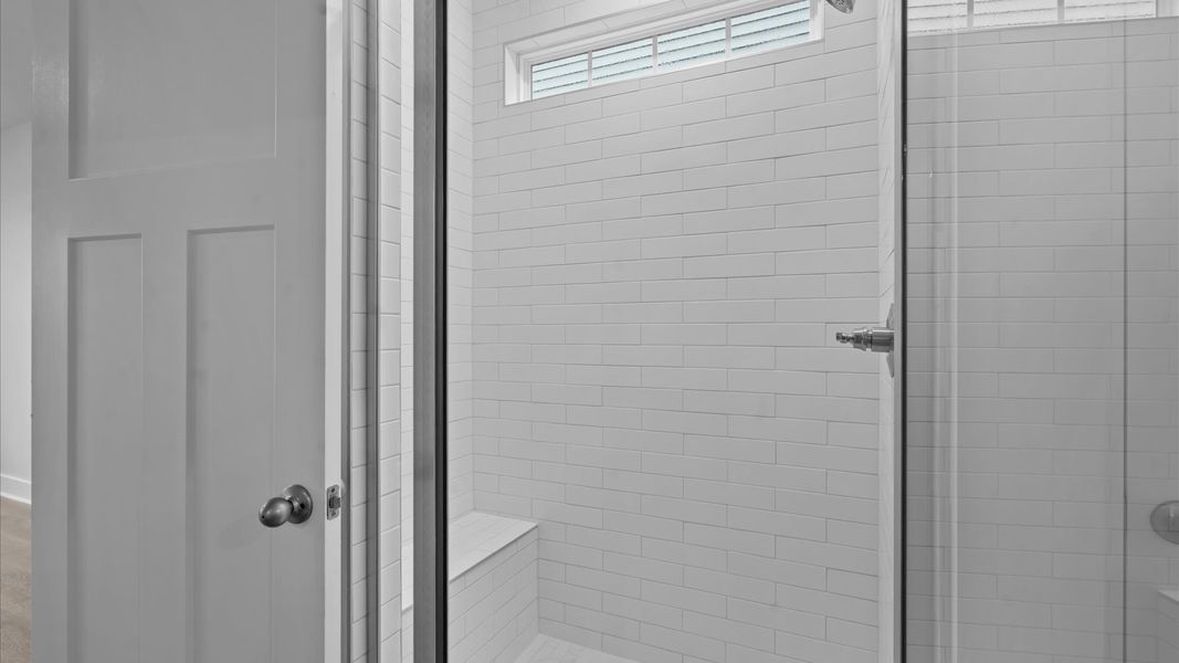 Memorable mornings begin in this elegant primary bathroom with tiled walk-in shower and double vanity Memorable mornings begin in this elegant primary bathroom with tiled walk-in shower and double vanity