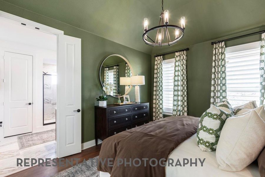 A cozy primary bedroom with French doors to the bathroom offers a private, elegant retreat for relaxation and comfort.