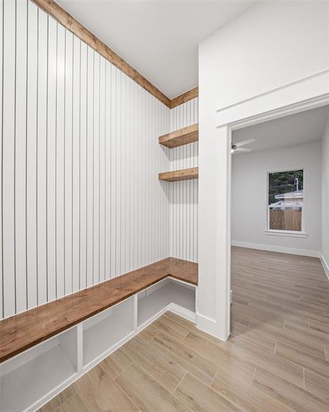 Built-in mudroom bench with wood-finish top and integrated storage cubbies Built-in mudroom bench with wood-finish top and integrated storage cubbies