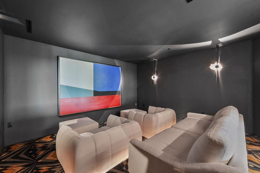 Dedicated media room featuring dark walls and ceiling, recessed lighting, and a projection screen