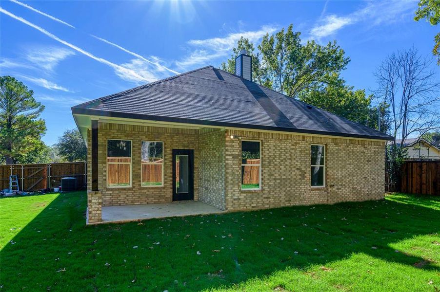 Rear view of property featuring central AC, a lawn, and a patio