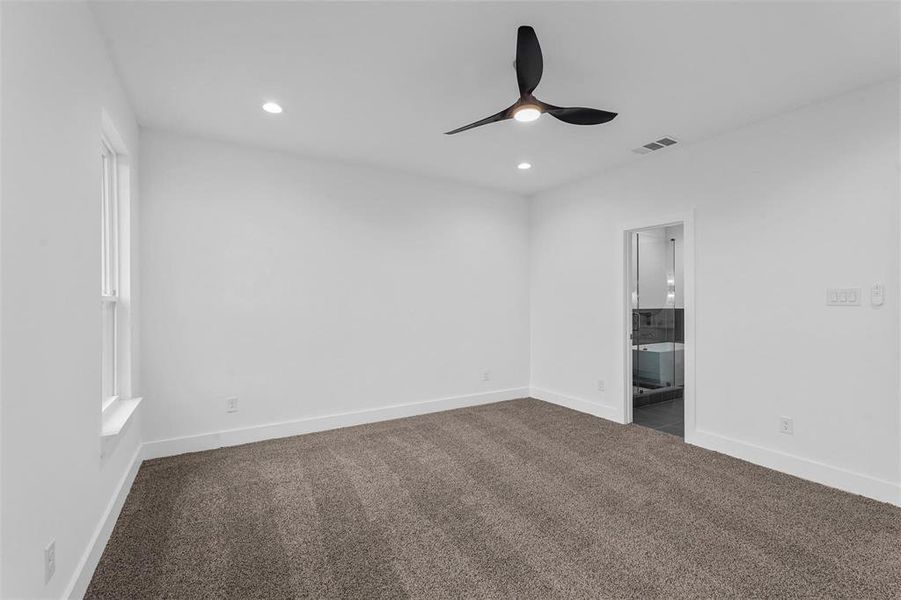 Unfurnished bedroom featuring dark carpet, recessed lighting, connected bathroom, and ceiling fan Unfurnished bedroom featuring dark carpet, recessed lighting, connected bathroom, and ceiling fan