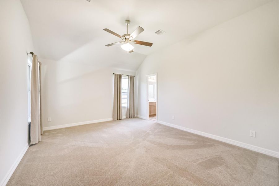 Welcome to your primary suite! This room features upgraded carpet with a half inch pad, a high vaulted ceiling, neutral paint, and windows that flood the space with natural light. Welcome to your primary suite! This room features upgraded carpet with a half inch pad, a high vaulted ceiling, neutral paint, and windows that flood the space with natural light.