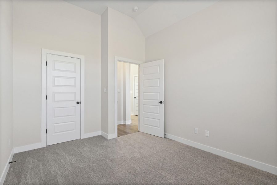 Unfurnished bedroom with carpet flooring, a closet, and high vaulted ceiling Unfurnished bedroom with carpet flooring, a closet, and high vaulted ceiling
