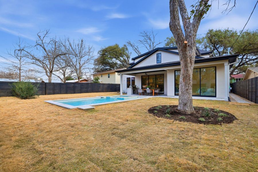 Back of house with a fenced backyard, a patio area, and ceiling fan