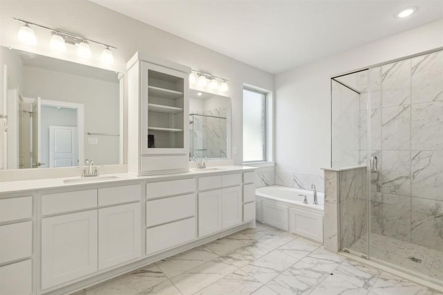 Bathroom featuring a wealth of natural light, a bathtub, and vanity