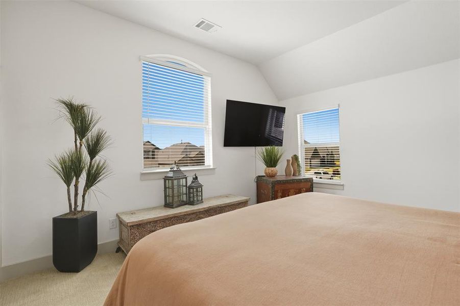 Bedroom with light carpet and vaulted ceiling Bedroom with light carpet and vaulted ceiling
