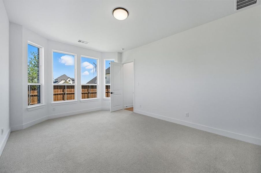 Unfurnished room with light carpet and baseboards Unfurnished room with light carpet and baseboards