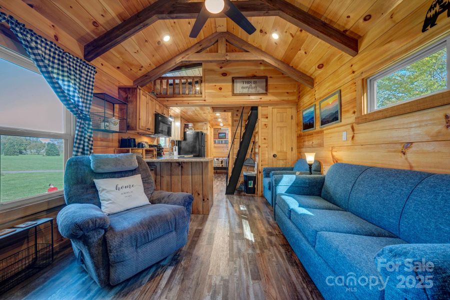 Living room with cathedral ceiling with beams and ceiling fan