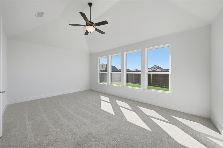 Empty room with vaulted ceiling, light carpet, and ceiling fan Empty room with vaulted ceiling, light carpet, and ceiling fan
