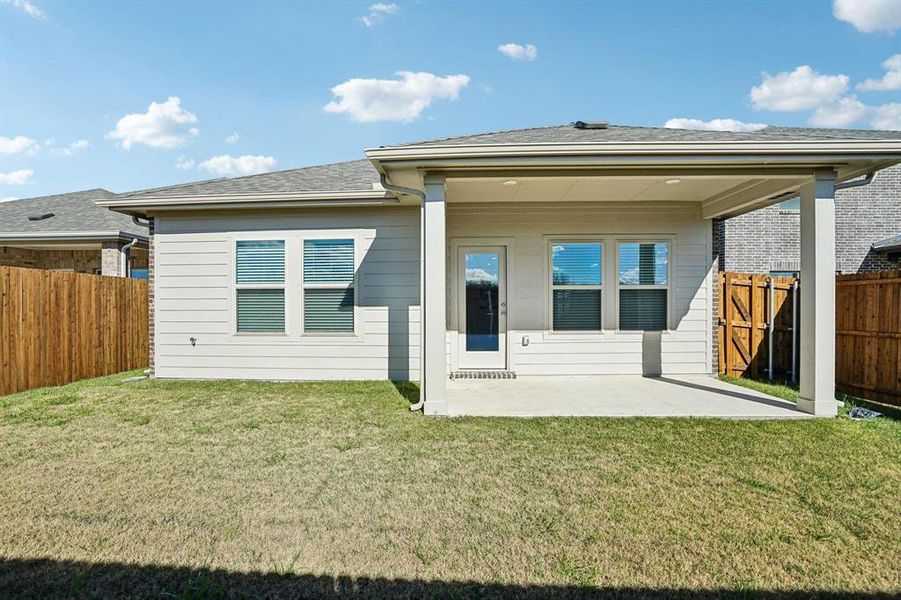 Back of house featuring a fenced backyard, a patio area, and roof with shingles