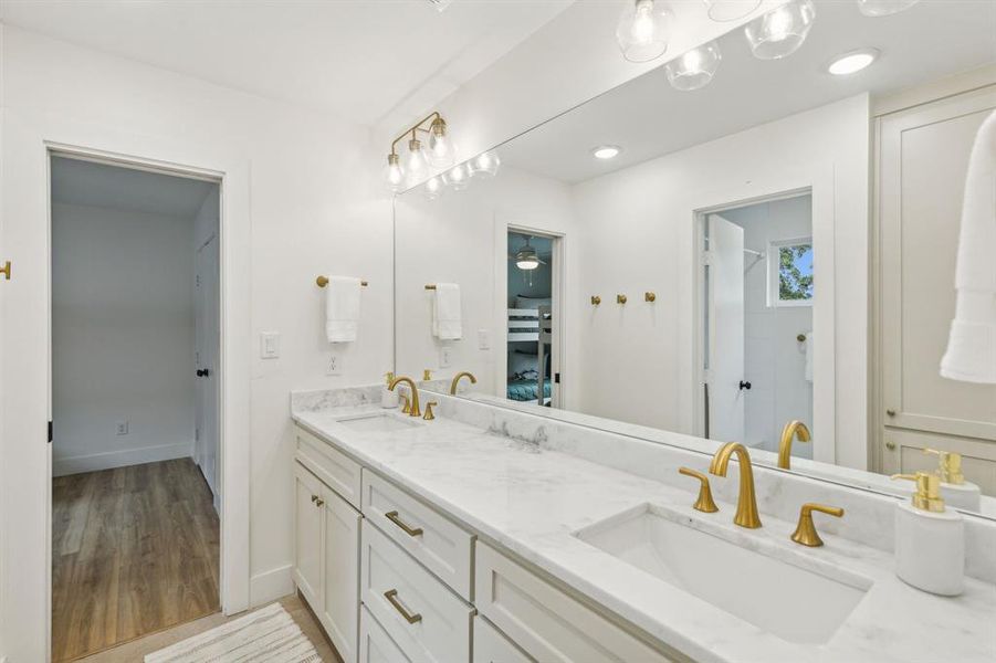 Bathroom with double vanity and wood-type flooring