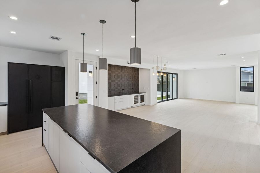 Kitchen with recessed lighting, open floor plan, pendant lighting, a center island, and light wood-style floors