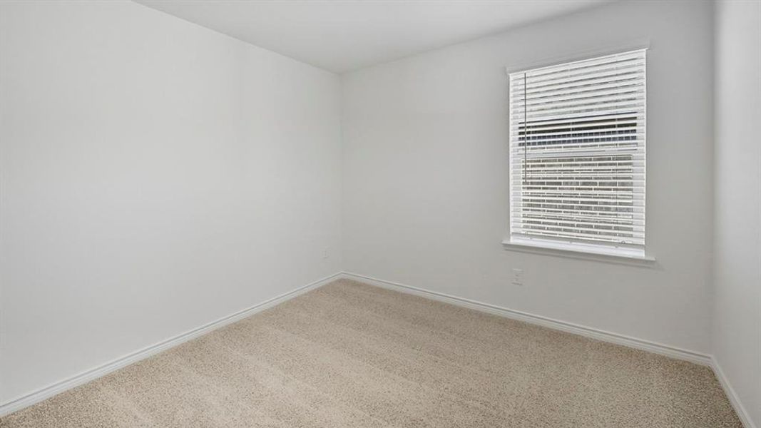 Spare room featuring carpet and baseboards