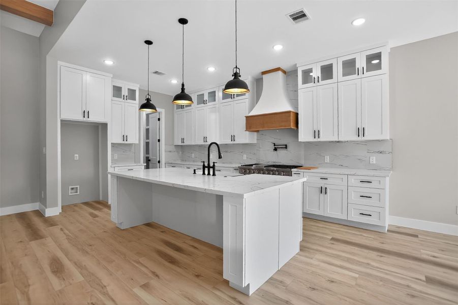 The kitchen features ample storage with floor to ceiling cabinets and a large walk-in pantry