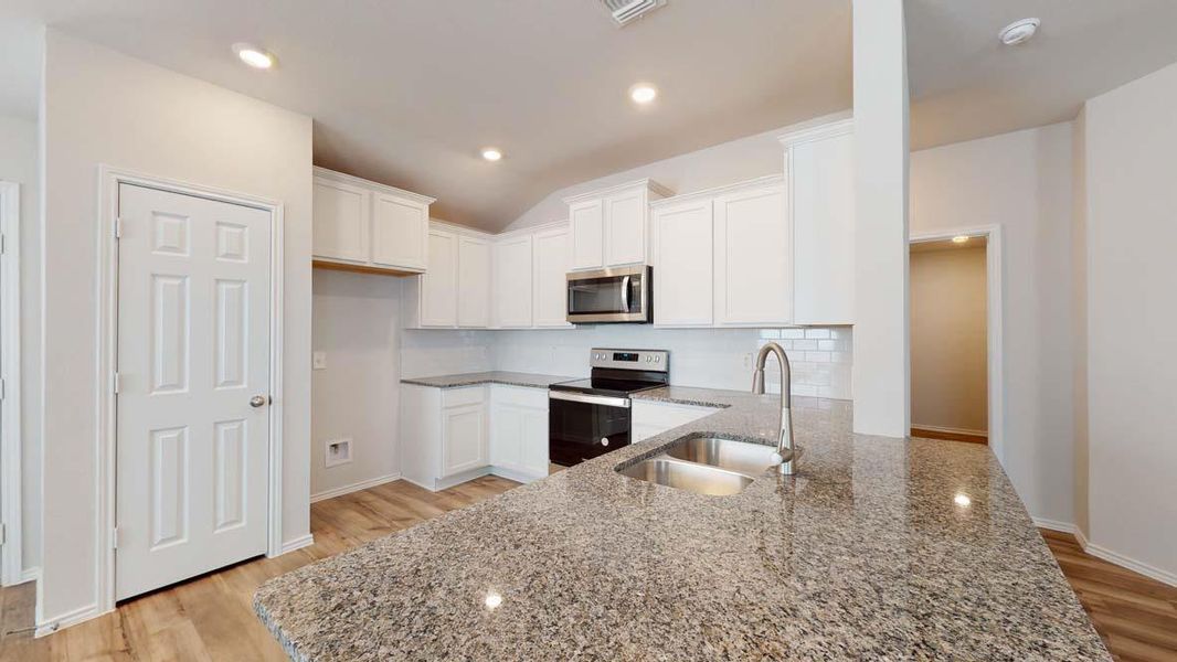 Kitchen with white cabinetry, stainless steel appliances, light stone countertops, light wood-style flooring, and recessed lighting