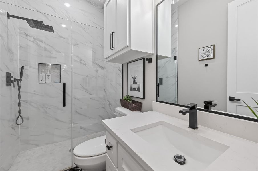 Secondary bathroom with walk-in shower and dual-sink vanity. Secondary bathroom with walk-in shower and dual-sink vanity.