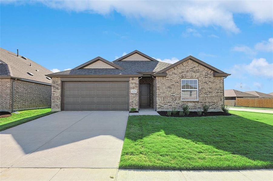 Ranch-style home featuring a garage and a front lawn