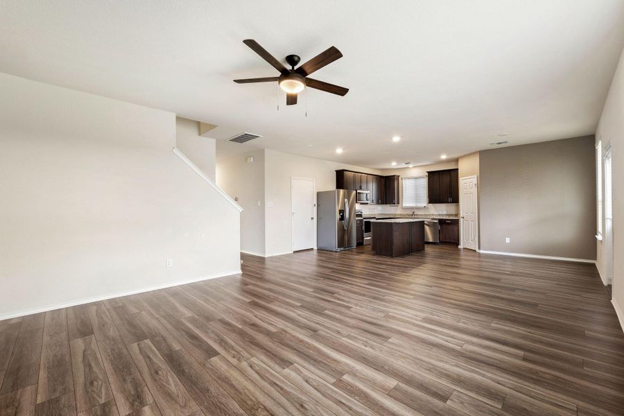 An open floorplan seamlessly connects the living space to a modern kitchen, featuring recessed lighting and durable flooring. Living room is open to the kitchen An open floorplan seamlessly connects the living space to a modern kitchen, featuring recessed lighting and durable flooring. Living room is open to the kitchen