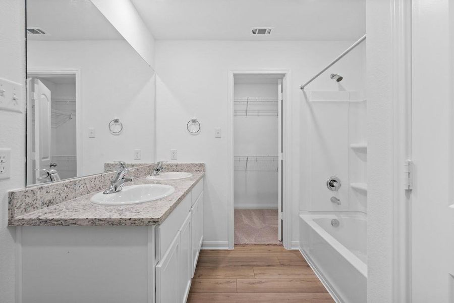 The primary bathroom includes granite countertops, double vanities, enclosed water closet and a walk-in closet.