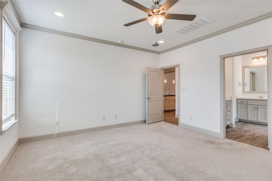 Unfurnished bedroom featuring light carpet, ornamental molding, a ceiling fan, recessed lighting, and ensuite bath Unfurnished bedroom featuring light carpet, ornamental molding, a ceiling fan, recessed lighting, and ensuite bath