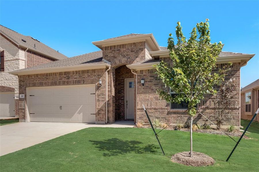 View of front facade featuring a garage and a front lawn