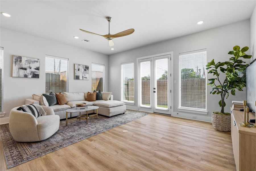 A bright, open living area anchored by oversized windows and double doors, bringing in natural light and creating a seamless connection to the backyard. A bright, open living area anchored by oversized windows and double doors, bringing in natural light and creating a seamless connection to the backyard.