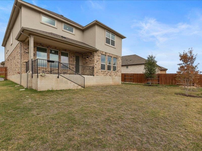 Rear view of property with brick siding, a patio area, and stucco siding