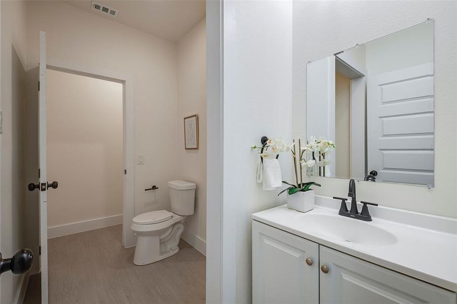 Bathroom with vanity, toilet, and hardwood / wood-style flooring